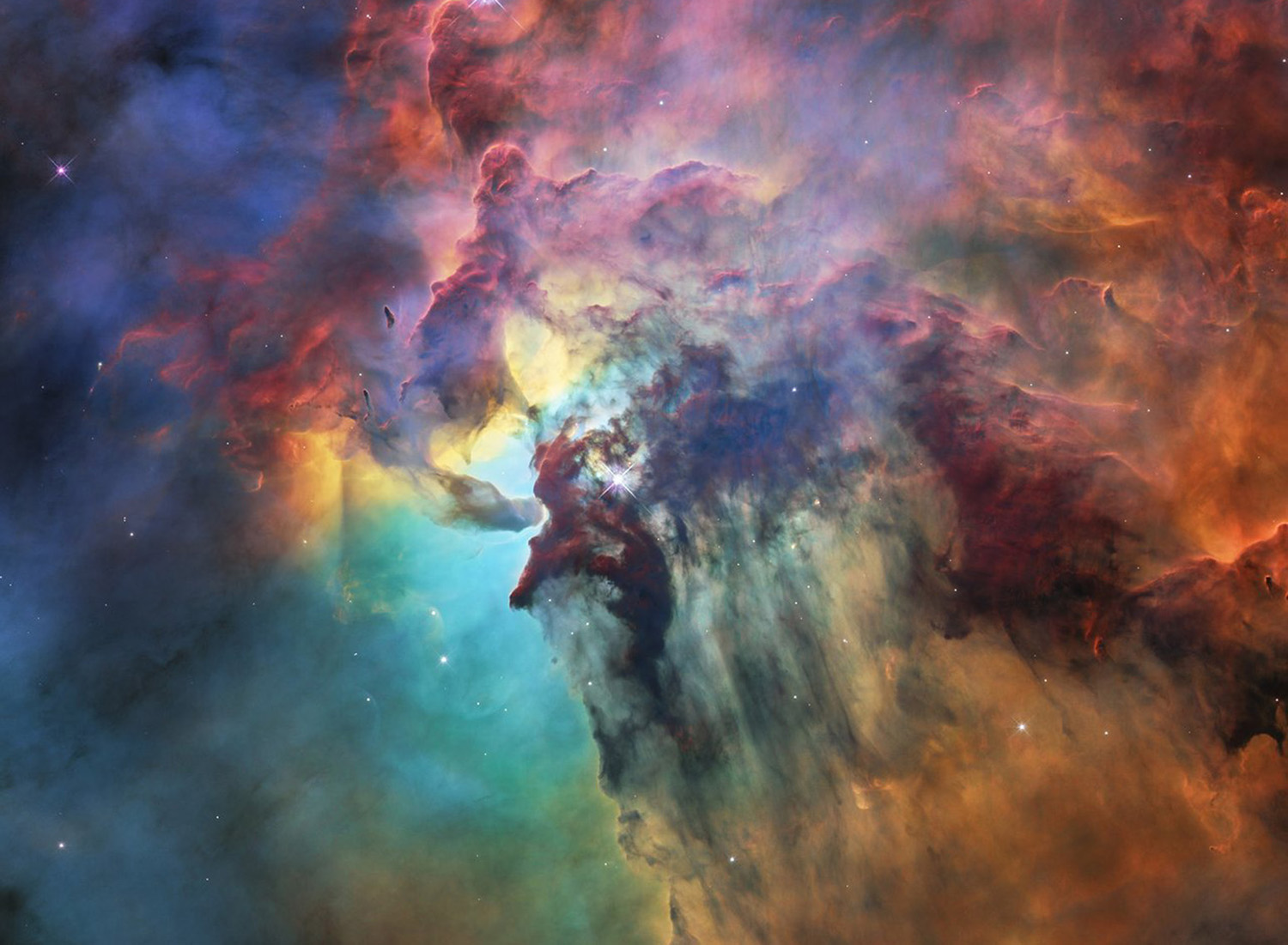 A vibrant image of a nebula, showcasing swirling clouds of gas and dust in shades of red, orange, blue and purple, with scattered stars throughout.